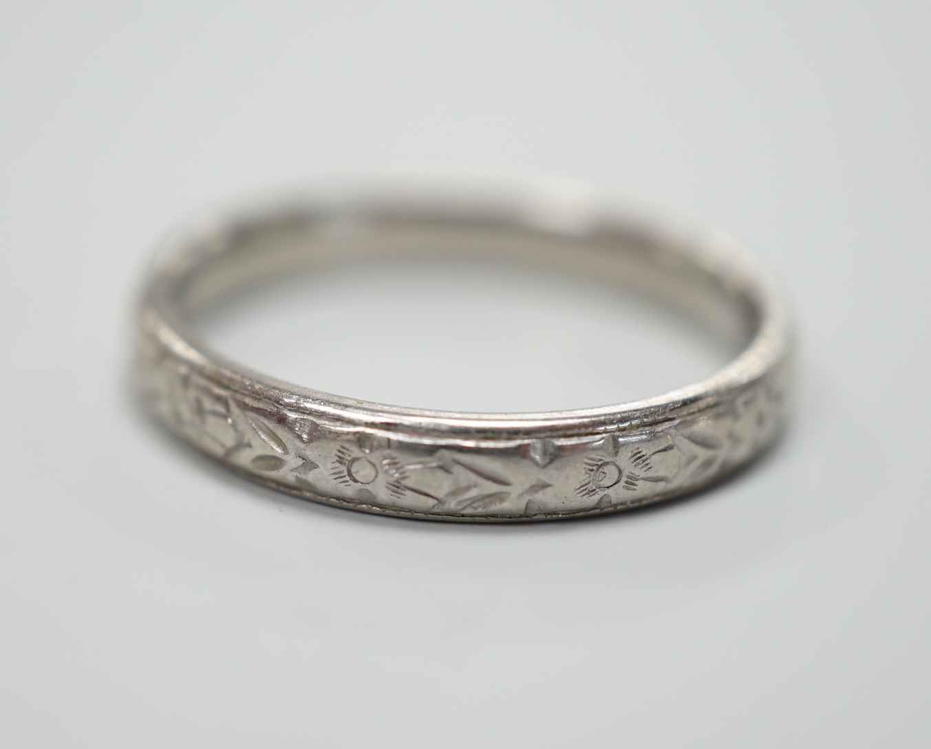 An engraved platinum wedding band, size M, 4.3 grams.